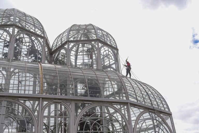 Funcionário realiza limpeza da cúpula da estufa do Jardim Botânico